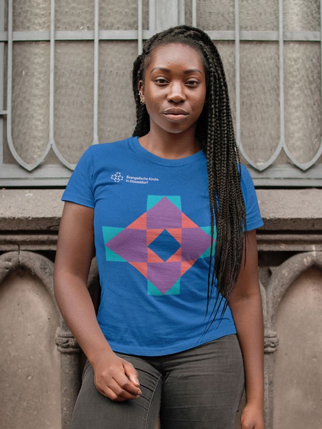 Eine junge Dame trägt ein blaues T-Shirt der Evangelischen Kirche in Düsseldorf. 